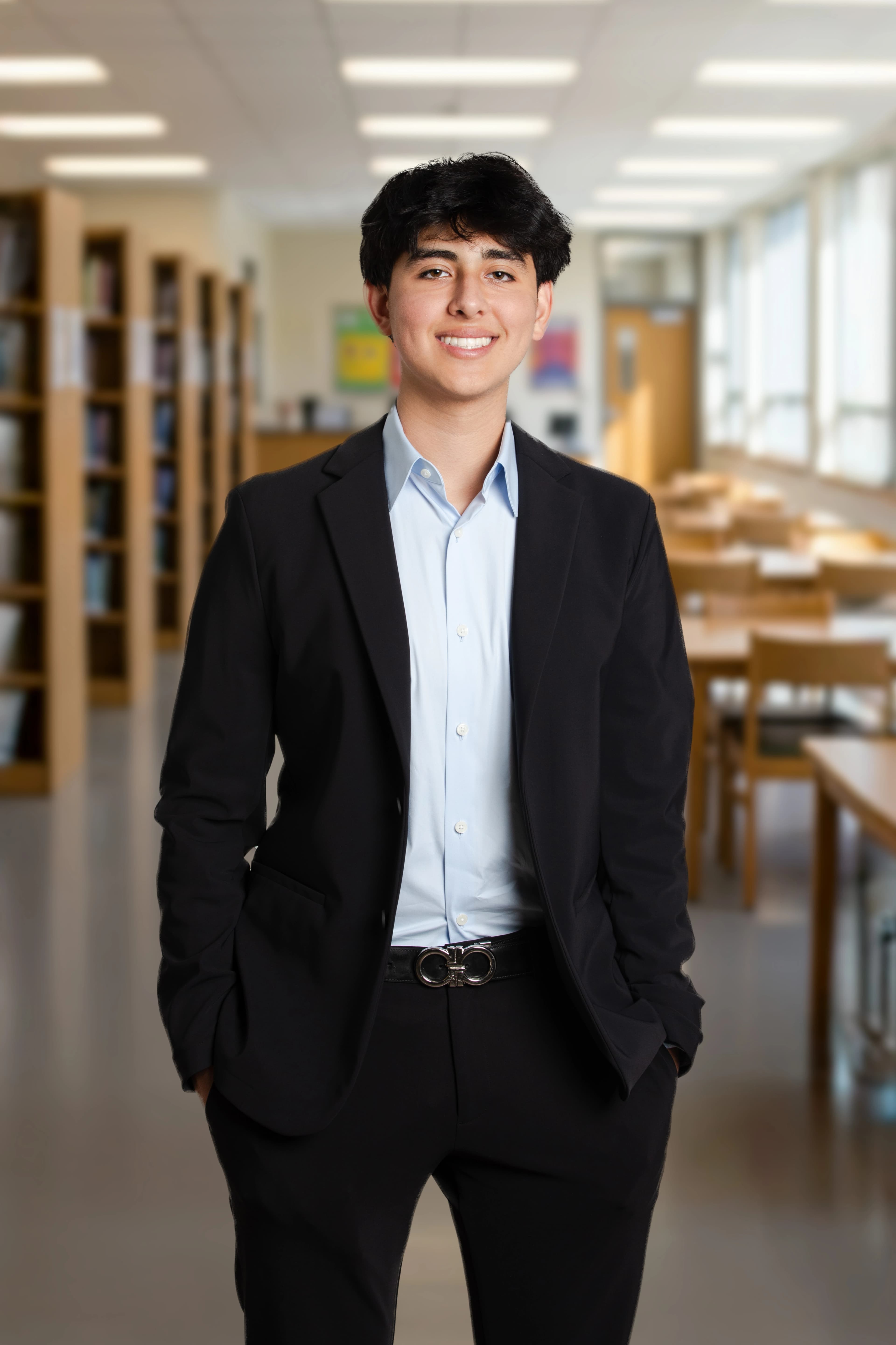 Modern open-plan office with exposed brick walls, large windows, wooden desks, and people working. One person descending metal staircase.